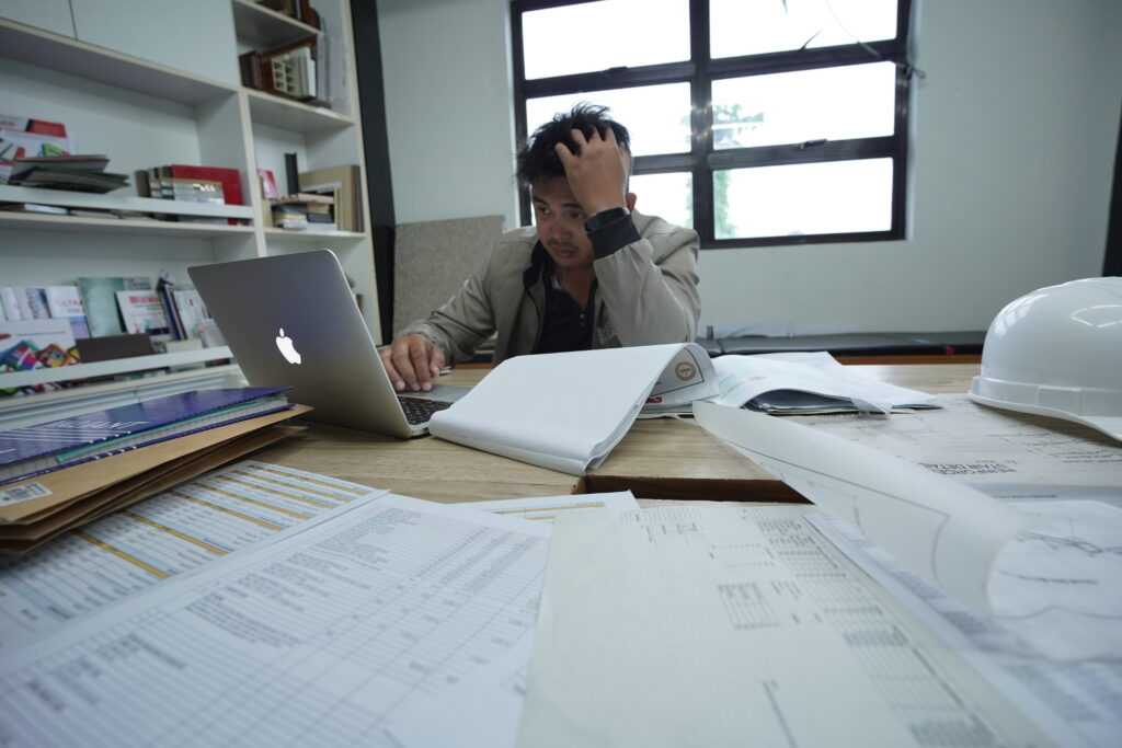 Construction manager overwhelmed by spreadsheets and disconnected tools, highlighting the need for clearer project visibility in 2026